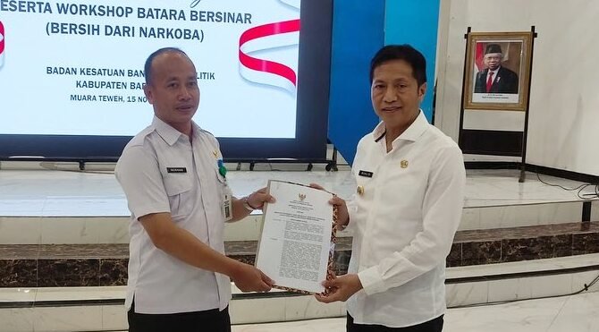 Pj. Bupati Barito Utara, Drs. Muhlis menyerahkan SK Bupati dan penetapan Kelurahan Jambu, sebagai Kelurahan Bersinar (Bersih dari Narkoba) kepada Lurah Jambu.(foto:Diskominfo)